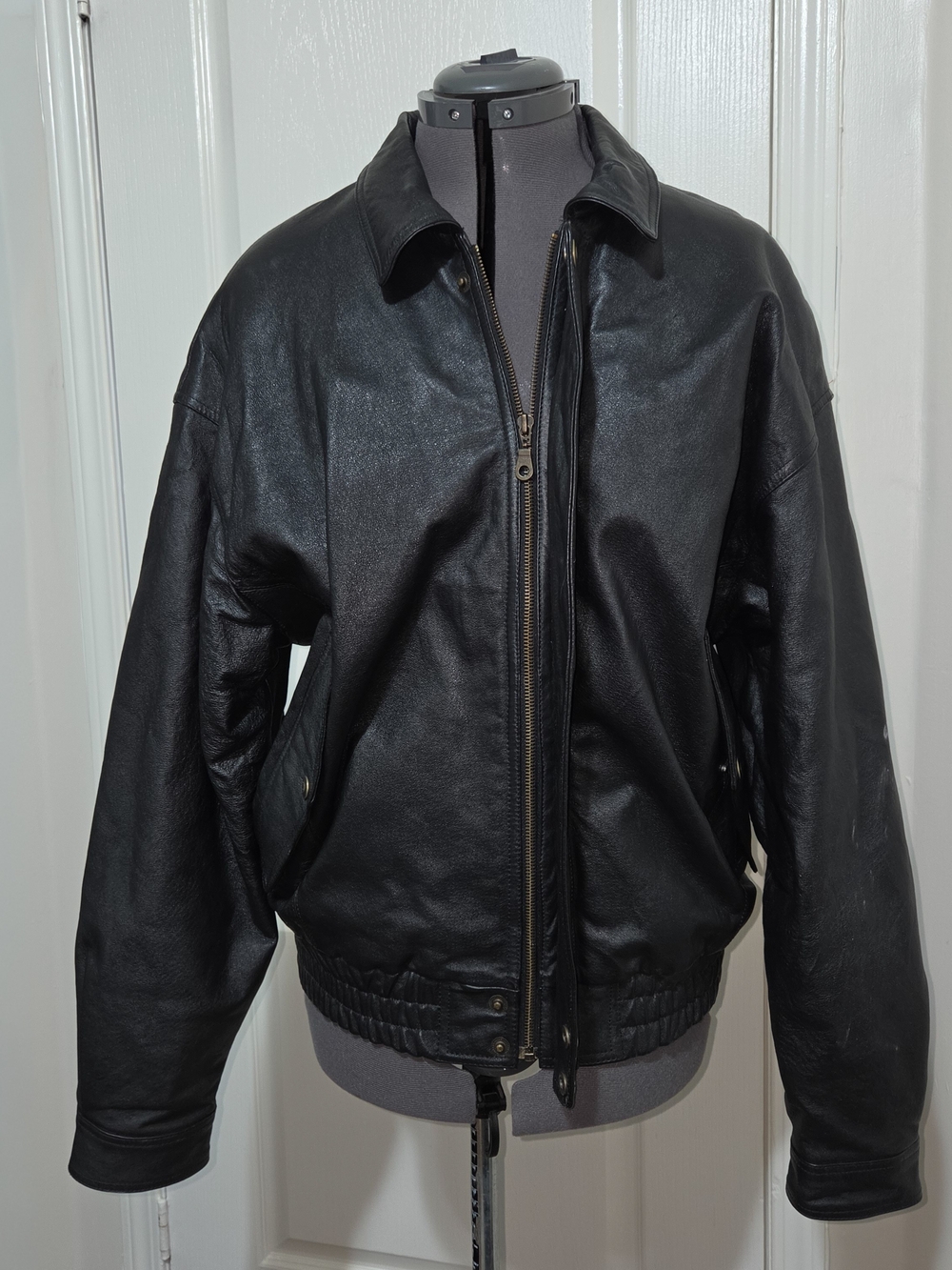 Black leather bomber jacket with zipper closure and elastic waistband